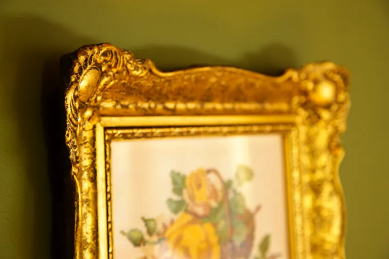 Goldrahmen an der grünen Wand