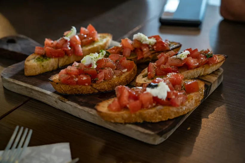 Bruschetta mit Tomaten auf einem Holzbrett